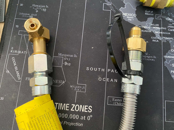 Image of a brass LH female connector and a flexible hose on a world map background, highlighting plumbing components.